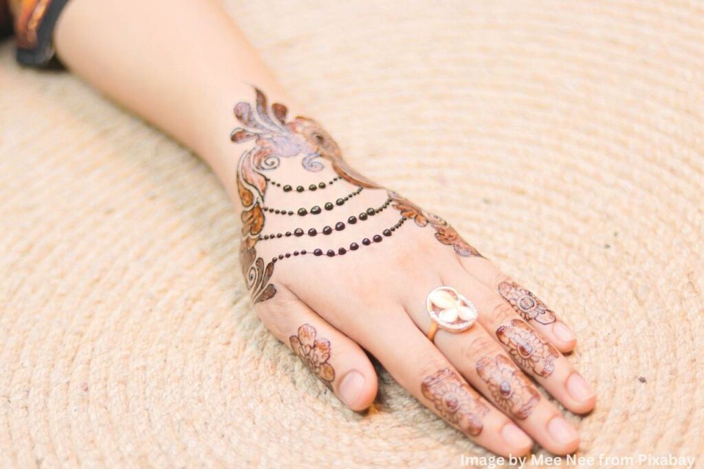 hand adorned with intricate mehndi patterns.