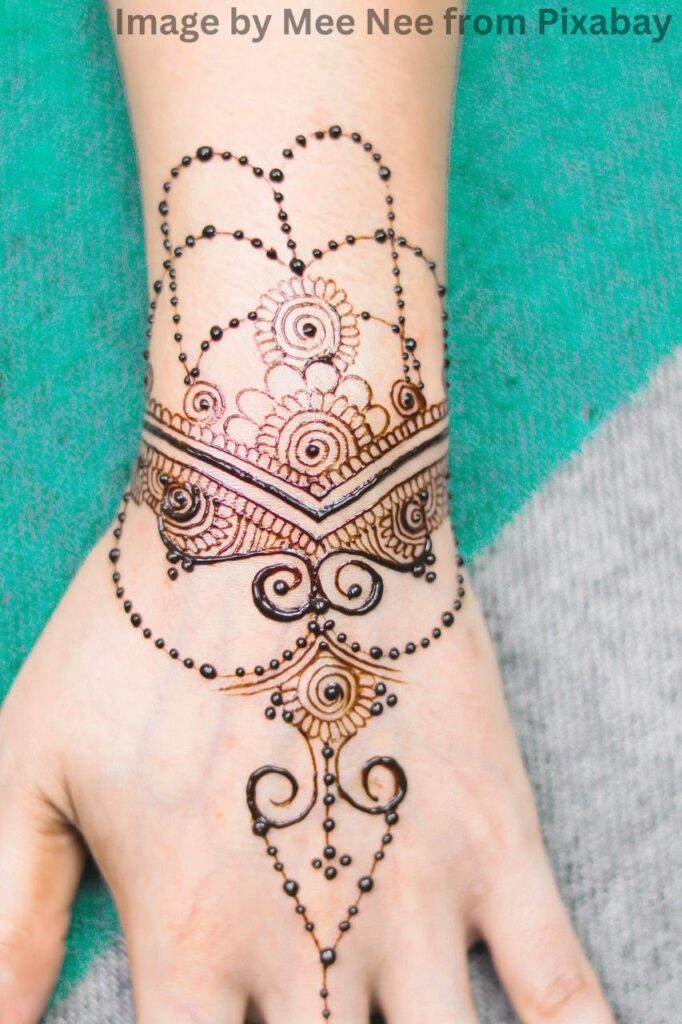 A woman's hand adorned with a mehandi design.