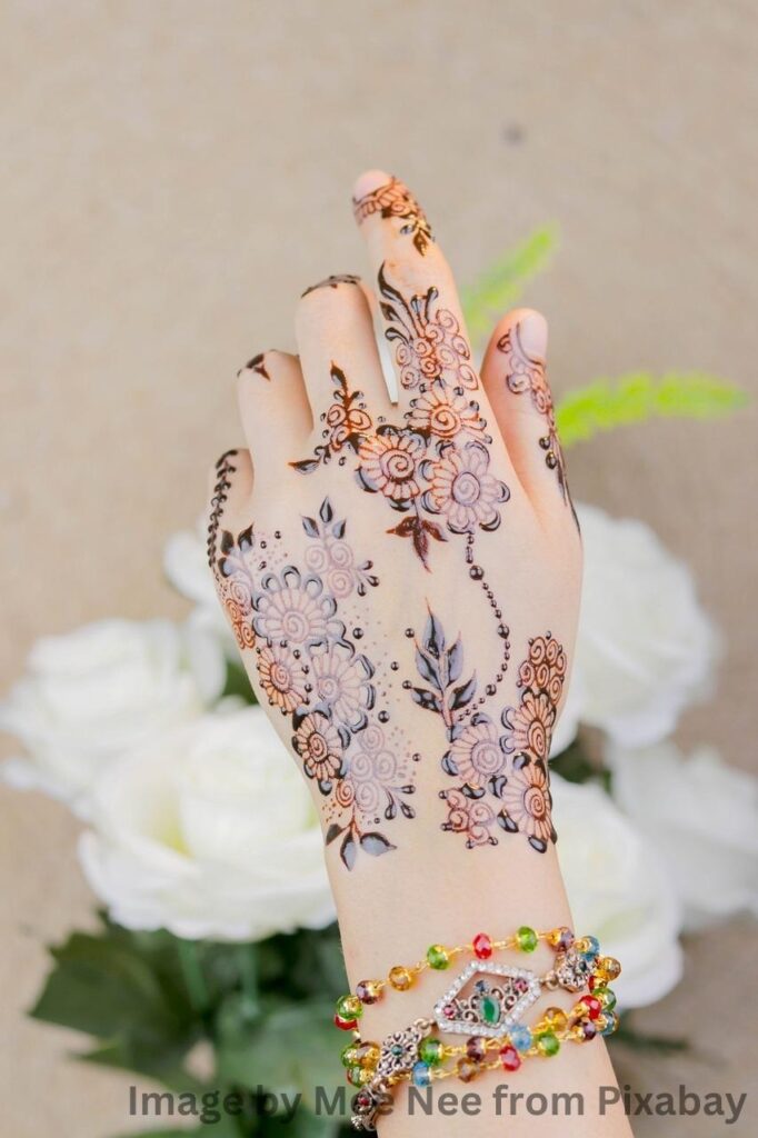 Mehandi-designed black henna tattoo on a woman's wrist.