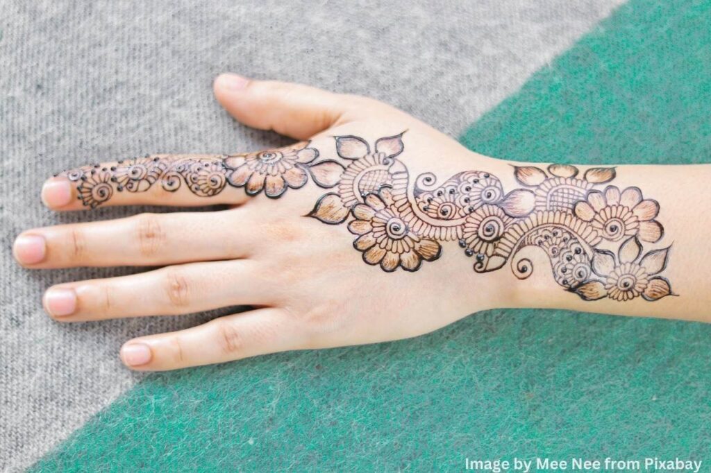 hand adorned with mehndi design patterns.