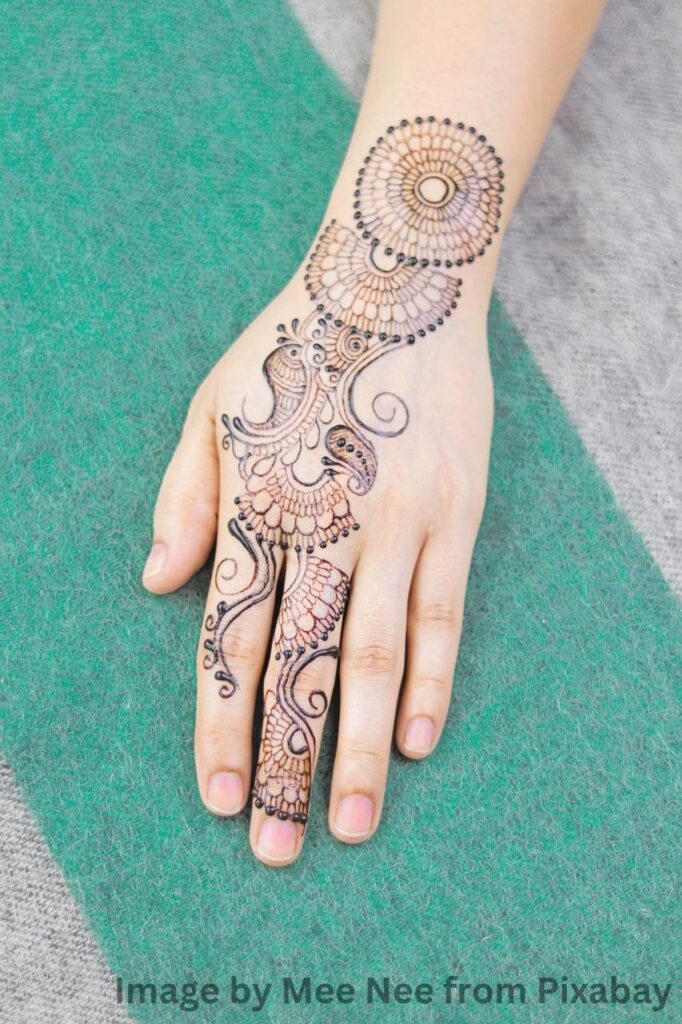 A woman's hand adorned with intricate mehandi designs.