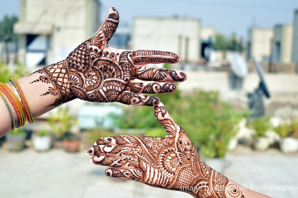 A lady show her both hand of mehndi design.