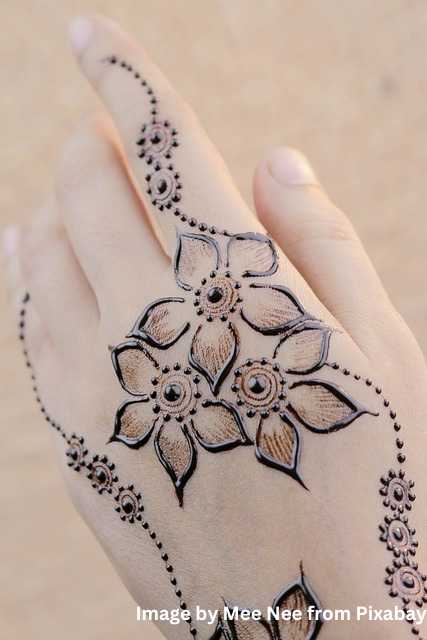 एक लड़की के हाथ पर शानदार फूलों वाली मेहंदी का डिजाइन फोटो।