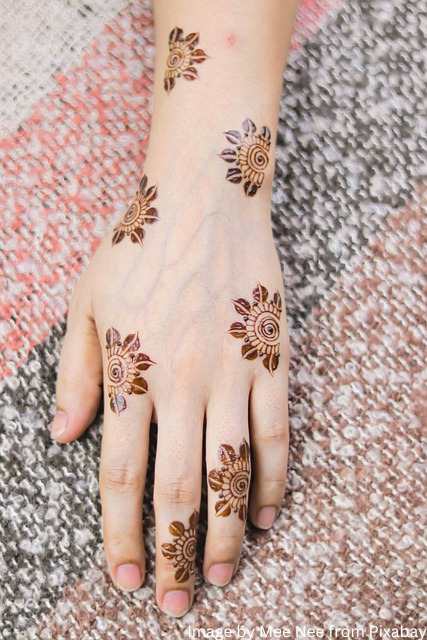मेहंदी डिजाइन फोटो of girl back hand with small flower design on her hand.