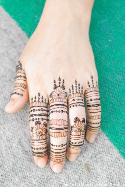 साधारण मेंहदी डिज़ाइन वाली एक महिला के हाथ। A woman hand with simple mehndi design of line pattern.